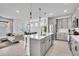 Open-concept kitchen with large island, stainless appliances, seamless transition to the living and dining area at 14317 Lanikai Beach Dr, Orlando, FL 32827