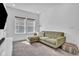 Relaxing living room with green sectional sofa and views from two large windows at 14317 Lanikai Beach Dr, Orlando, FL 32827