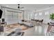 Bright living room with modern gray sofa, tile flooring, and contemporary geometric rug near dining area at 14317 Lanikai Beach Dr, Orlando, FL 32827
