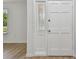 Bright entryway with glass-paneled door and pristine white trim, complementing the wood-look floors at 1484 Patricia St, Kissimmee, FL 34744