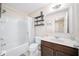 Clean bathroom with a shower-tub combo, vanity, and shelving, offering a functional and stylish space at 1625 Smokey Oak Way, Longwood, FL 32750