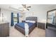Comfortable bedroom boasts a tray ceiling, ceiling fan, a plush bed with blue accents, and dual nightstands at 1625 Smokey Oak Way, Longwood, FL 32750