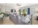 Living area with a cozy gray sectional and a view of the private backyard with an outdoor seating area at 1625 Smokey Oak Way, Longwood, FL 32750