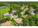 An aerial view of a home within a community near a golf course, water, and many mature trees at 1679 Shadowmoss Cir, Lake Mary, FL 32746