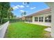 Lush backyard featuring green grass, secure fencing, and an exterior view of the screened-in lanai at 1679 Shadowmoss Cir, Lake Mary, FL 32746