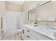 Well-lit bathroom features a double sink vanity with marble countertop and bathtub with white tile surround at 1679 Shadowmoss Cir, Lake Mary, FL 32746