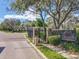 A street view of a gated entrance with brick sidewalk and brick wall and mature tree at 1679 Shadowmoss Cir, Lake Mary, FL 32746