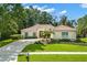 Charming single-story home with a tile roof, manicured landscaping, and a circular driveway at 1679 Shadowmoss Cir, Lake Mary, FL 32746