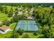 Aerial view of well-maintained tennis courts and lush green landscaping in the neighborhood at 1679 Shadowmoss Cir, Lake Mary, FL 32746