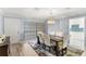 Dining room featuring modern chandelier, white chairs, and access to the kitchen at 17 Hibiscus Ct, Eustis, FL 32726