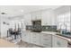 Bright kitchen boasts white cabinets, mosaic backsplash, stainless hood, and quartz countertops at 17 Hibiscus Ct, Eustis, FL 32726