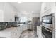 Modern kitchen featuring stainless steel appliances, white cabinets, and mosaic backsplash at 17 Hibiscus Ct, Eustis, FL 32726