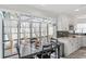 Eat-in kitchen area with black dining set next to sunroom with cathedral windows and glass roof at 17 Hibiscus Ct, Eustis, FL 32726