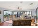 Inviting sunroom with tile flooring, ceiling fan, and walls of glass overlooking the landscaped backyard at 17 Hibiscus Ct, Eustis, FL 32726