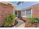 Inviting townhouse entrance with brick accents and pathway lined with vibrant flowers and plants at 17 Lawn St, Oviedo, FL 32765