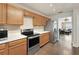 Modern kitchen with stainless steel appliances, light wood cabinets, and an adjoining living area at 17 Lawn St, Oviedo, FL 32765