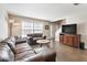 Comfortable living room featuring leather sofas, a round coffee table, and ample natural light at 17 Lawn St, Oviedo, FL 32765
