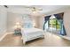 Bright main bedroom with a ceiling fan, lamps, balcony access, and hardwood floors at 17 Lawn St, Oviedo, FL 32765