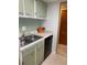 Kitchen featuring light green cabinets, laminate countertops, and stainless steel sink and dishwasher at 1935 Conway Rd # R5, Orlando, FL 32812