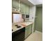 Kitchen featuring light green cabinets, laminate countertops and black appliances at 1935 Conway Rd # R5, Orlando, FL 32812