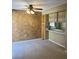 A cozy living room with carpet flooring, unique textured wall, and open shelving, plus a ceiling fan at 1935 Conway Rd # R5, Orlando, FL 32812