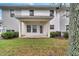 Backyard patio area with door and trimmed shrubs. Grassy lawn and shaded by mature trees at 2026 Cypress Bay Blvd, Kissimmee, FL 34743