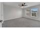 Neutral bedroom featuring plush gray carpeting, bright windows, and ceiling fan at 2026 Cypress Bay Blvd, Kissimmee, FL 34743