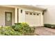 Attached garage door with decorative windows and manicured front yard landscaping at 2026 Cypress Bay Blvd, Kissimmee, FL 34743