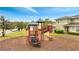 Community playground with slide and climbing structure, surrounded by lush green space at 2026 Cypress Bay Blvd, Kissimmee, FL 34743
