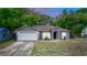 Charming single-story home features a gray exterior, arched entryway, well-manicured lawn, and an attached garage at 216 Clara Vista St, Debary, FL 32713