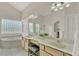 Large bathroom features double sinks, tub, and large glass block window at 2230 Lake Crescent Ct, Windermere, FL 34786