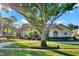 Well-maintained single-story home with a circular driveway and manicured landscaping, framed by a large tree at 2230 Lake Crescent Ct, Windermere, FL 34786