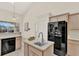 Open kitchen featuring an island, black appliances, and neutral walls at 2230 Lake Crescent Ct, Windermere, FL 34786