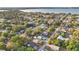 Expansive aerial view of a neighborhood featuring houses among lush trees, with a waterfront in the backdrop at 226 Noxon St, Auburndale, FL 33823