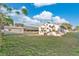 Large backyard with green grass and a neighboring structure surrounded by a white picket fence at 226 Noxon St, Auburndale, FL 33823