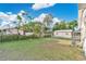 Large backyard with an air conditioning unit, a lawn and fence surrounded by green trees at 226 Noxon St, Auburndale, FL 33823