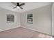 Cozy bedroom with neutral carpet, two large windows, and a modern ceiling fan at 226 Noxon St, Auburndale, FL 33823