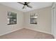 Well-lit bedroom with neutral carpet, closet, and two windows providing natural light at 226 Noxon St, Auburndale, FL 33823