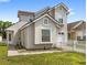 Charming two-story home featuring stucco siding, white picket fence, and well-maintained front yard at 2361 Carriage Run Rd, Kissimmee, FL 34741