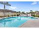 This inviting community pool includes a fenced-in area, tables, and landscaping at 2361 Carriage Run Rd, Kissimmee, FL 34741