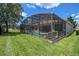 Enjoy the private screened pool and patio in this backyard featuring lush green lawn at 2631 Archfeld Blvd, Kissimmee, FL 34747
