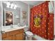 Well-lit bathroom featuring a shower and vanity with themed wall decor at 2631 Archfeld Blvd, Kissimmee, FL 34747