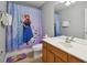 Bathroom with white vanity and shower featuring a colorful, kid-friendly curtain at 2631 Archfeld Blvd, Kissimmee, FL 34747