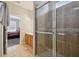 En-suite bathroom boasting tiled floors, shower behind glass doors and cherry wood vanity at 2631 Archfeld Blvd, Kissimmee, FL 34747