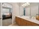 Bathroom vanity with dual sinks and a mirror with views of the carpeted bedroom at 2631 Archfeld Blvd, Kissimmee, FL 34747