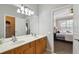 Bathroom featuring dual sinks, walk-in closet, and views of bedroom, and modern fixtures at 2631 Archfeld Blvd, Kissimmee, FL 34747