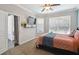 Neutral colored bedroom with carpet, fan, queen bed, window, and wall-mounted television at 2631 Archfeld Blvd, Kissimmee, FL 34747
