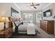 Primary bedroom with window, fan, dresser, bedside tables, and a queen sized bed at 2631 Archfeld Blvd, Kissimmee, FL 34747
