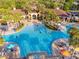 Aerial view of a stunning resort-style pool with palm trees and ample seating at 2631 Archfeld Blvd, Kissimmee, FL 34747