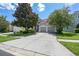 Beautiful home featuring a two-car garage, well-manicured lawn, and mature trees enhancing curb appeal at 2631 Archfeld Blvd, Kissimmee, FL 34747